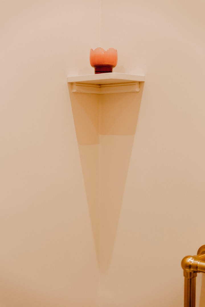 Corner shelf with decorative item.