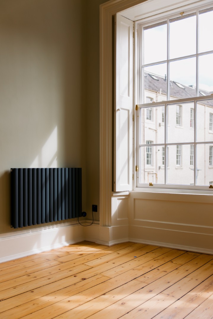 Bright room with wooden floor and radiator.