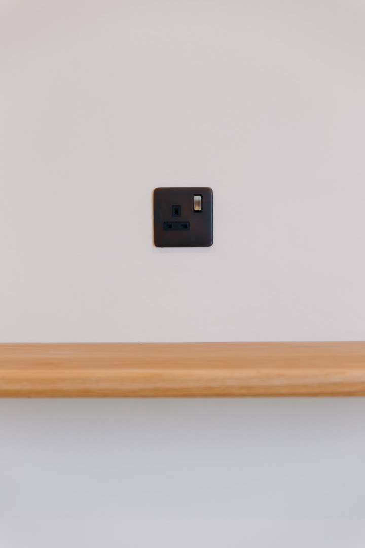 Black socket on plain white wall.