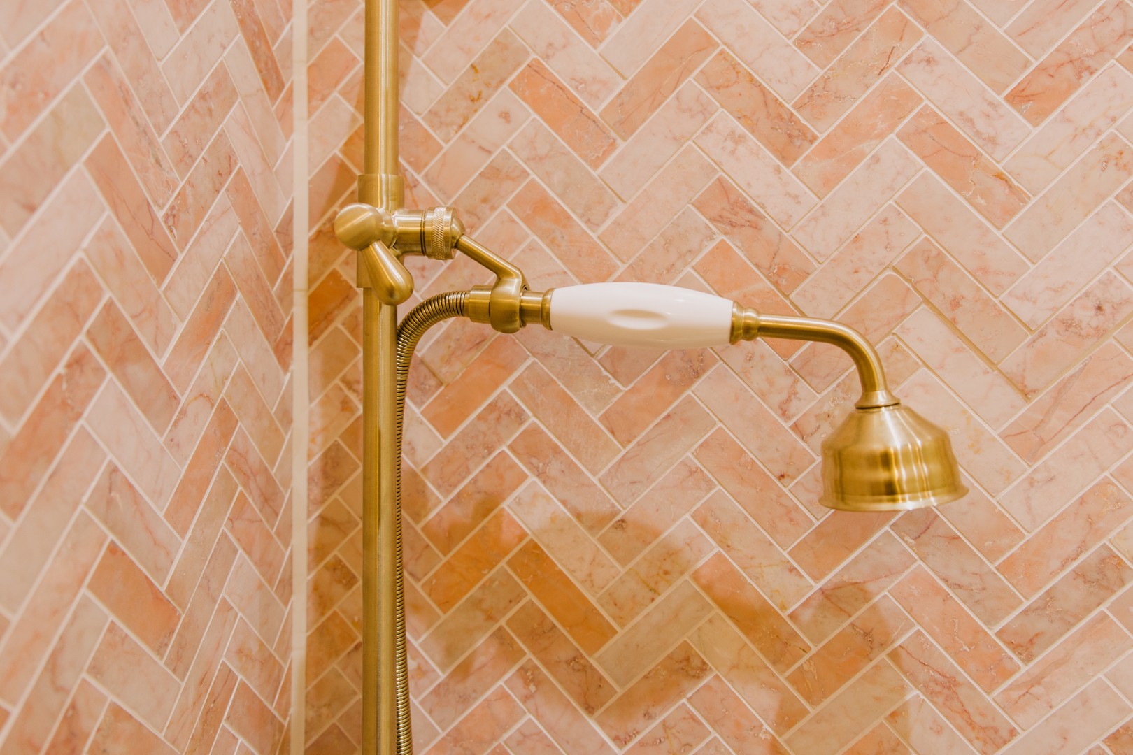 Elegant shower fixture against herringbone tiles.
