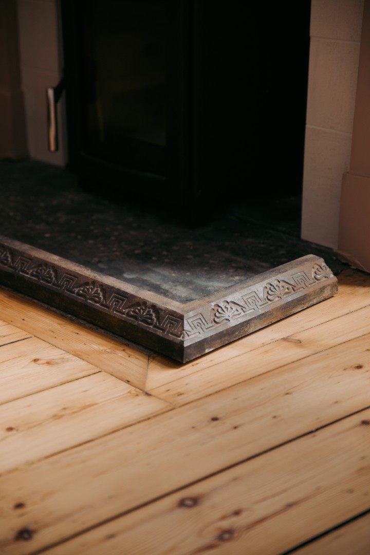 Elegant fireplace corner with wooden flooring.