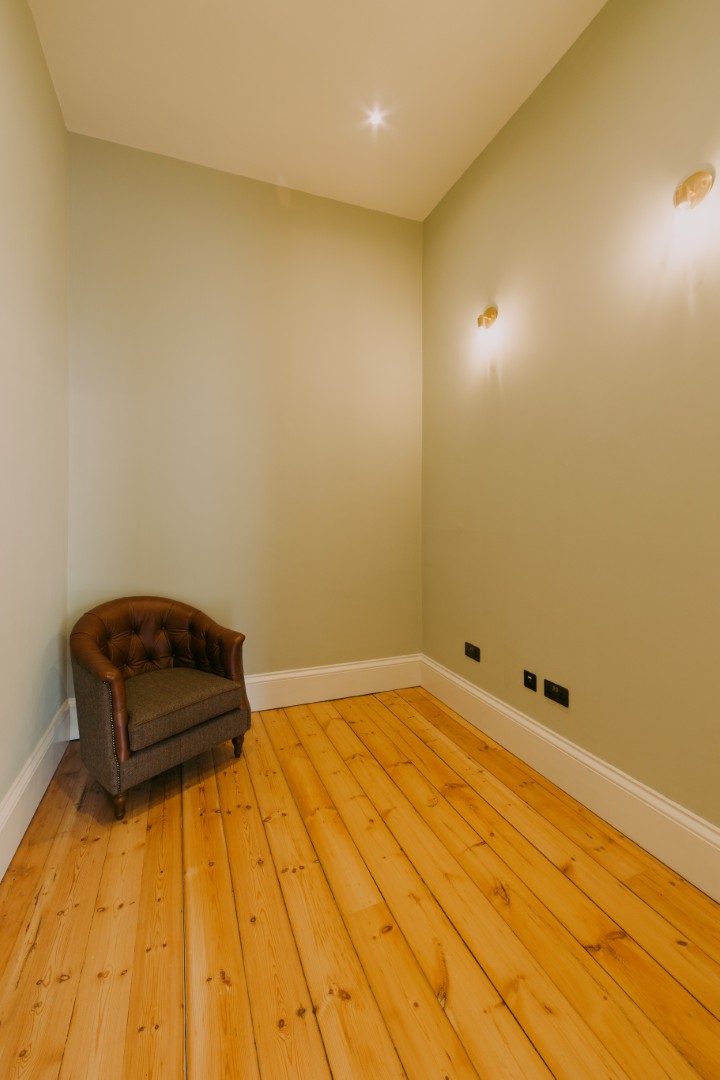 Empty room with wooden flooring and chair.