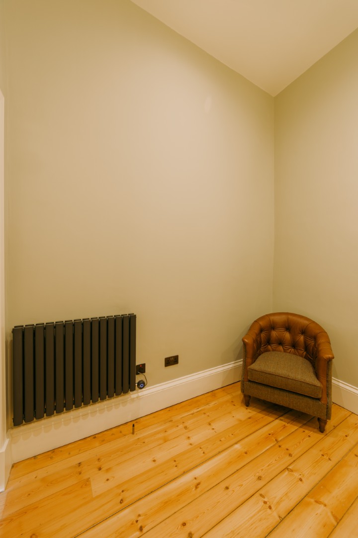 Empty room with radiator and chair