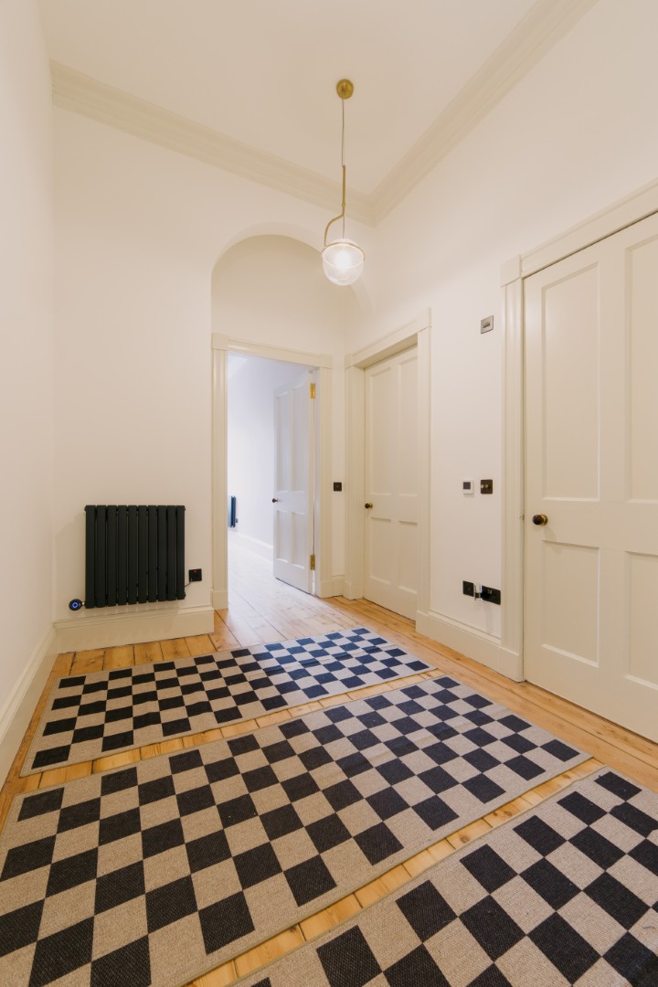 Spacious hallway with checkered flooring.