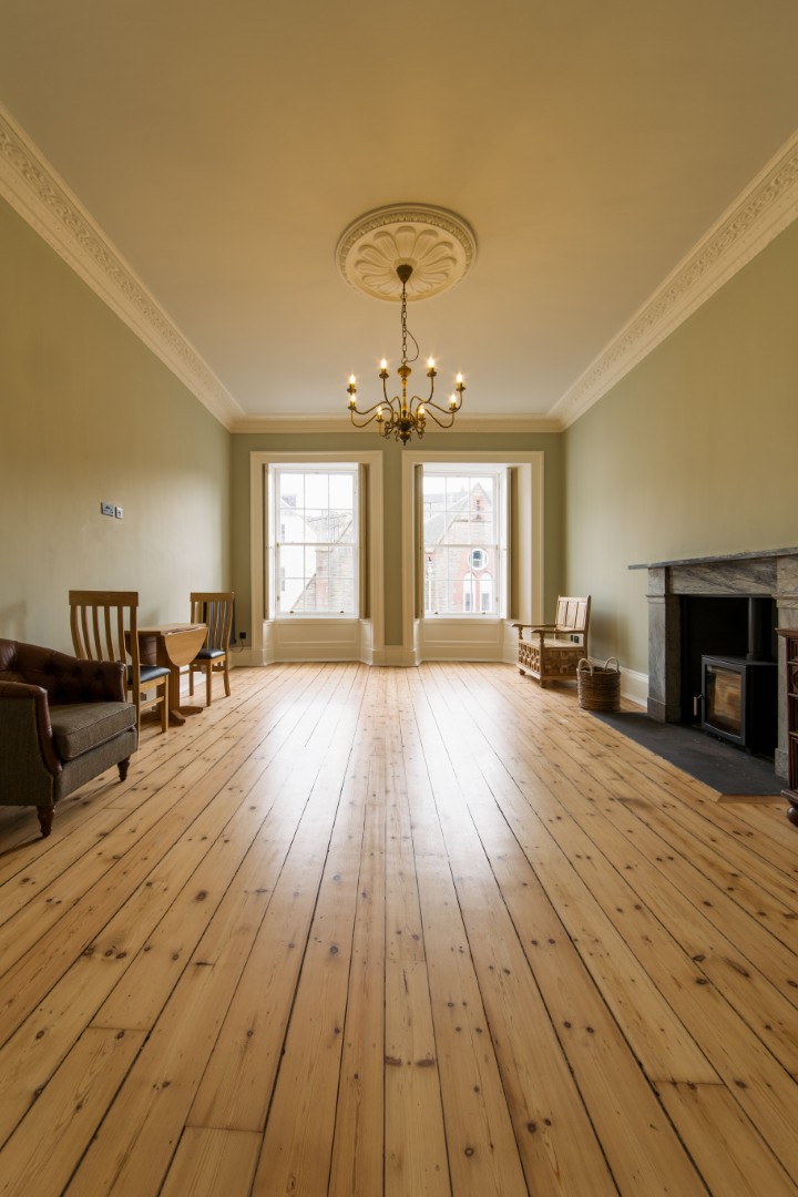 Spacious room with wooden flooring and chandelier