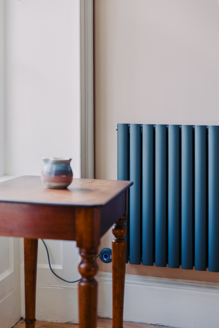 Wooden table beside a blue radiator.