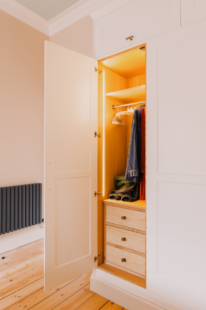 Bright, organised wardrobe with wooden interior.